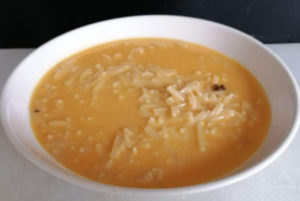 Sopa de cocido servida en cuenco con fideos