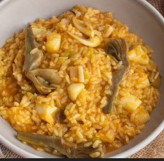 Arroz meloso de sepia y alcachofas presentado en cazuela